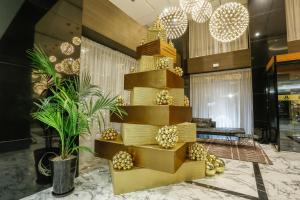 a gold spiral staircase in a lobby with a palm tree at Royal Tulip City Center in Tangier