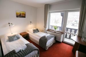 um quarto de hotel com duas camas e uma janela em Rudy Lis Szczyrk em Szczyrk