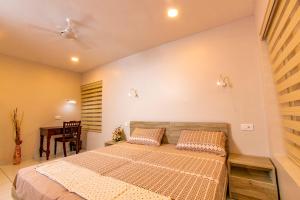 1 dormitorio con 1 cama grande y 1 mesa en Sanskriti en Thiruvananthapuram