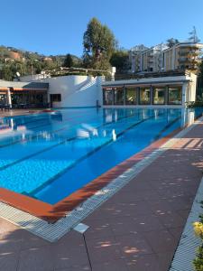 una grande piscina con un edificio sullo sfondo di Sara by PortofinoVacanze a Rapallo