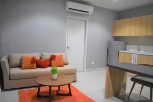 Una sala de estar con un sofá y una mesa y una cocina. en i-City-Casa Rosa - Wifi - Netflix - Movies - Parking - Sleeps 5 pax, en Shah Alam