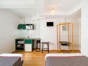 ein kleines Zimmer mit 2 Betten und einer Küche in der Unterkunft Hostal Athenas in Sant Adria de Besos