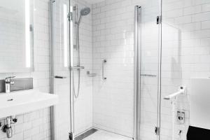 
a bathroom with a shower, sink, and mirror at Radisson Blu Atlantic Hotel, Stavanger in Stavanger
