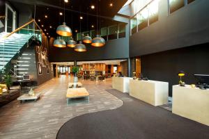 a lobby of a building with tables and chairs at Radisson Blu Hotel Nydalen, Oslo in Oslo