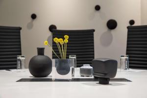 a table with black vases and yellow flowers on it at Radisson Blu Airport Hotel, Oslo Gardermoen in Gardermoen