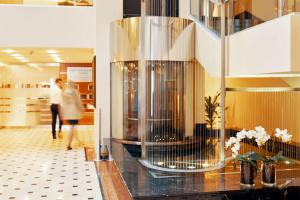 a lobby with a person walking in a building at Radisson Blu Ridzene Hotel, Riga in Rīga