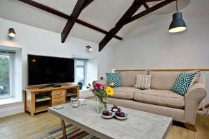 a living room with a couch and a tv at The Barn, 21 At The Beach, Torcross in Beesands