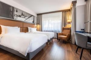 a hotel room with two beds and a desk at Radisson Blu Hotel Prague in Prague