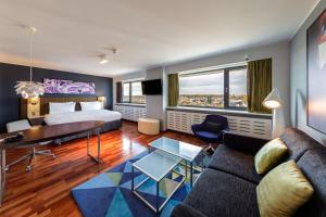 ヴィリニュスにあるラディソン ブルー ホテル リエッヴァのベッドとソファ付きのホテルルーム