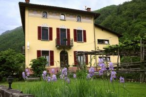 ein Haus mit lila Blumen davor in der Unterkunft Unione in Gordevio