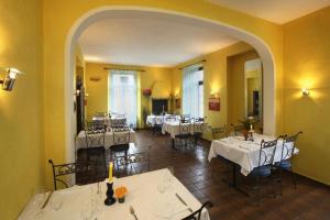 restauracja z białymi stołami i krzesłami oraz łukiem w obiekcie Unione w mieście Gordevio