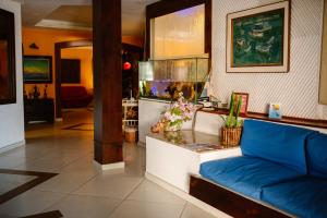 a living room with a blue couch and a fish tank at Hotel La Brise in Cabo Frio