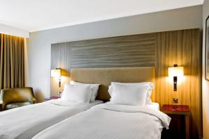 a hotel room with a bed and two lamps at Radisson Blu Manchester Airport in Hale