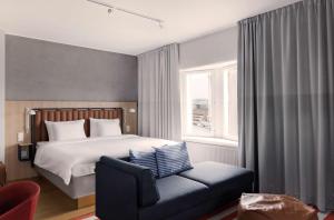 a bedroom with a bed and a chair and a window at Radisson Blu Seaside Hotel, Helsinki in Helsinki