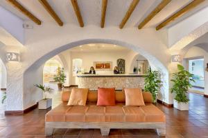 a couch in a living room with an archway at Colonna Grand Hotel Capo Testa in Santa Teresa Gallura