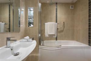 a bathroom with a tub and a sink and a bath tub at Park Inn by Radisson Shannon Airport in Shannon
