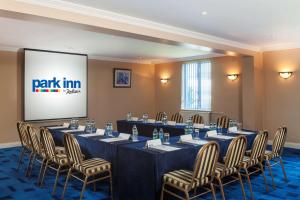 a conference room with a table and chairs and a screen at Park Inn by Radisson Shannon Airport in Shannon