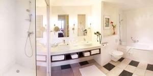 a bathroom with two sinks and a shower and a toilet at Radisson Blu Hotel Paris, Marne-la-Vallée in Magny-le-Hongre