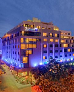un bâtiment d'hôtel avec un panneau sur celui-ci la nuit dans l'établissement Radisson Blu Martinez Beirut, à Beyrouth