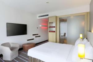 a hotel room with a bed and a tv at Radisson Blu Media Harbour Hotel, Düsseldorf in Düsseldorf