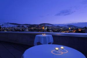 a table on a balcony with a view of the city at Radisson Blu Hotel, St. Gallen in St. Gallen
