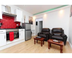 a living room with two leather chairs and a table at Balmain Apartments in Leeds