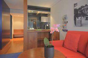 ein Wohnzimmer mit einem roten Sofa und einem Tisch in der Unterkunft Radisson Blu Hotel, St. Gallen in St. Gallen