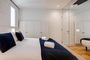 - une chambre avec un grand lit blanc et des oreillers bleus dans l'établissement Chic & Trendy T.M. Flat, à Lisbonne