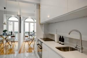 - une cuisine blanche avec un évier et une table dans l'établissement Chic & Trendy T.M. Flat, à Lisbonne