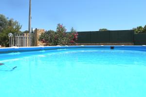 una grande piscina di acqua blu in un cortile di Villa Luigi a Torre Pali