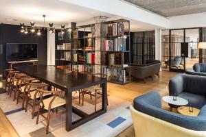 uma sala de estar com mesa e cadeiras e uma biblioteca em Radisson Blu Hotel, London Mercer Street em Londres