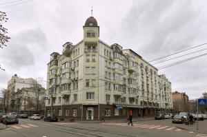 a large white building with a clock tower on a street at 1BR apartment in the old city center (Kyïv) in Kyiv