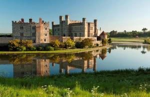 a castle with its reflection in a body of water at Balmain Apartments in Leeds