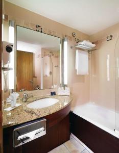 ein Badezimmer mit einem Waschbecken, einer Badewanne und einem Tubermott in der Unterkunft Radisson Blu Hotel, Athlone in Athlone