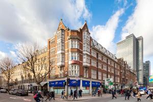 a group of people crossing a street in front of a building at Radisson Blu Hotel, London Euston Square in London