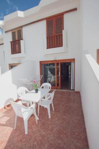 a patio with white tables and chairs on a building at Montecarlo Apartamento30 in Puerto Rico de Gran Canaria