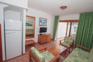 a living room with a refrigerator and a table and chairs at Montecarlo Apartamento30 in Puerto Rico de Gran Canaria