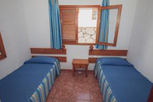 a small room with two beds and a window at Montecarlo Apartamento30 in Puerto Rico de Gran Canaria