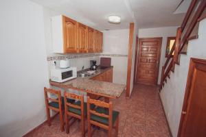 a kitchen with a counter with chairs and a microwave at Montecarlo Apartamento30 in Puerto Rico de Gran Canaria