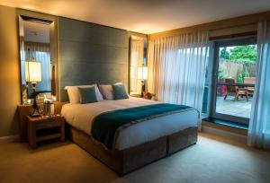 a bedroom with a large bed and a balcony at Radisson BLU Hotel & Spa, Little Island Cork in Cork