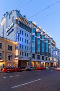 a large building with cars parked in front of it at Park Inn by Radisson Nevsky in Saint Petersburg