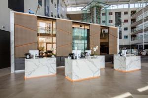 a lobby with three white counter tops in a building at Radisson Blu Hotel London Stansted Airport in Stansted Mountfitchet