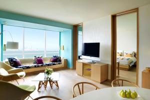 クウェートにあるSymphony Style Hotel Kuwaitのソファとテレビのあるリビングルーム