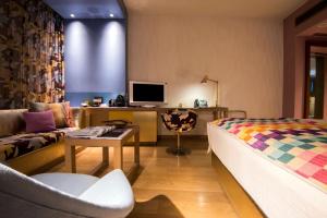 a living room with a couch and a tv at Symphony Style Hotel Kuwait in Kuwait
