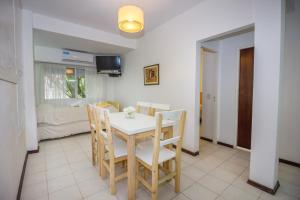 een eetkamer met een witte tafel en stoelen bij La Casona de Valeria in Valeria del Mar