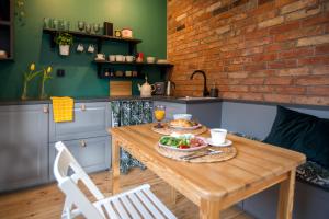 uma cozinha com uma mesa de madeira com uma tigela de comida em SeaFolks Apartments em Gdynia