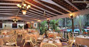 a restaurant with tables and chairs and a balcony at Park Inn by Radisson Goa Candolim in Candolim