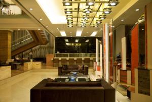 a lobby with a couch and a chair in a building at Radisson Blu Hotel Pune Kharadi in Pune