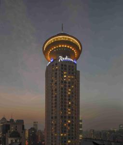 a tall building with a sign on the top of it at Radisson Blu Hotel Shanghai New World in Shanghai