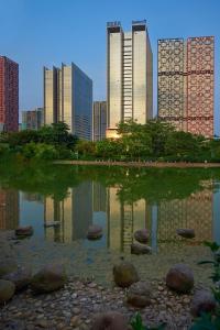 eine Reflexion von Gebäuden in einem Teich in einer Stadt in der Unterkunft Radisson Blu Hotel Liuzhou in Liuzhou